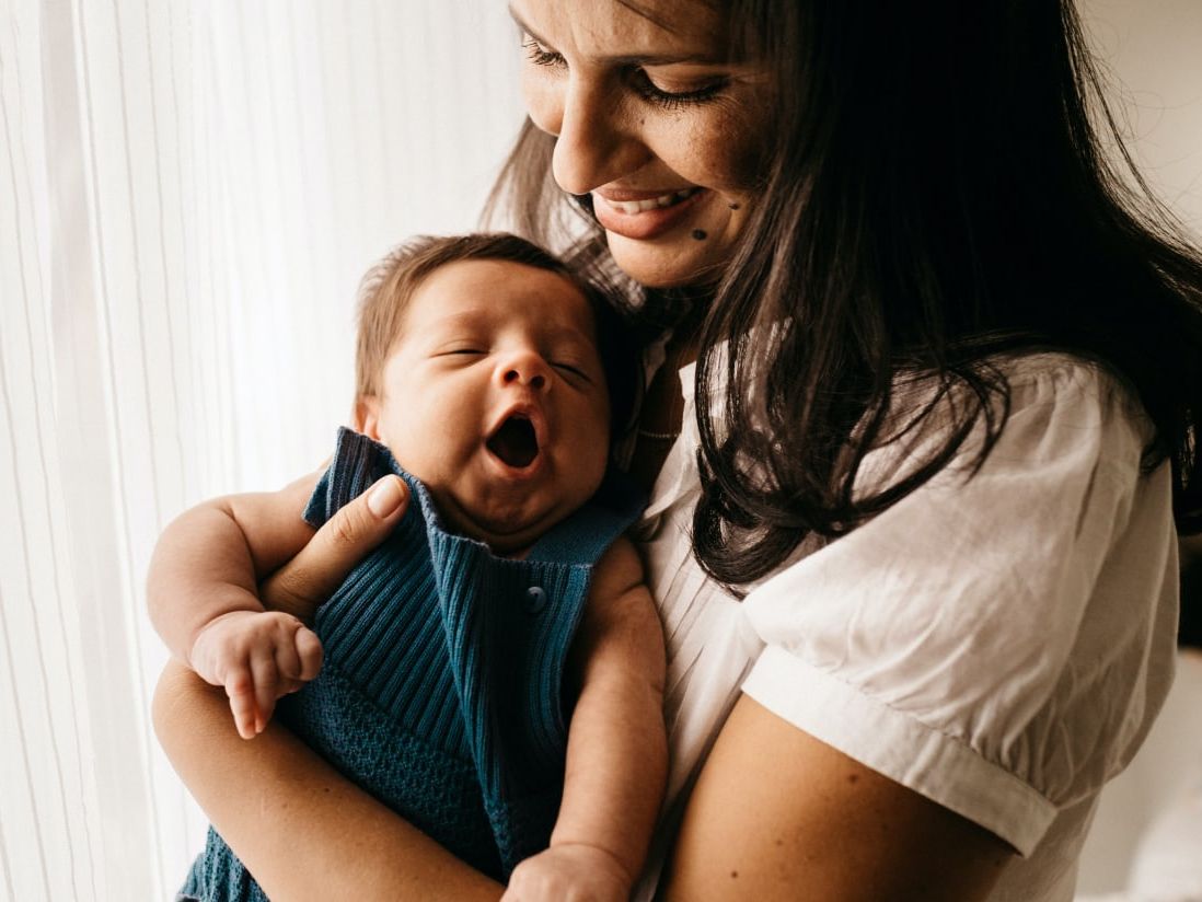 picture of woman with long hair holding very young baby